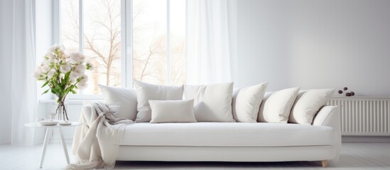 Obraz na płótnie Canvas A white couch is positioned neatly next to a window in a stylish living room with Scandinavian interior design. The room exudes a modern and minimalistic aesthetic.