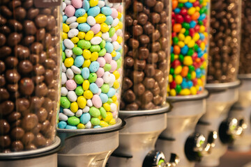 Transparent containers with multi-colored sweets and candy in the store, confectionery, selective focus.