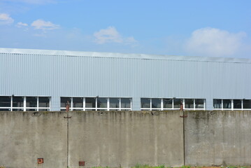 Warehouse building with concrete walls and white metal-plastic windows.