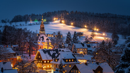 Illuminated houses and church in Seiffen at Christmastime. Saxony, Germany