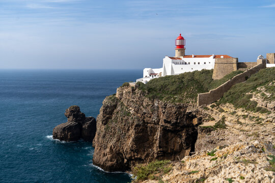 Ein Leuchtturm an der K&uuml;ste thront auf den Felsen &uuml;ber dem Meer in Portugal an der Algarve bei Sagres