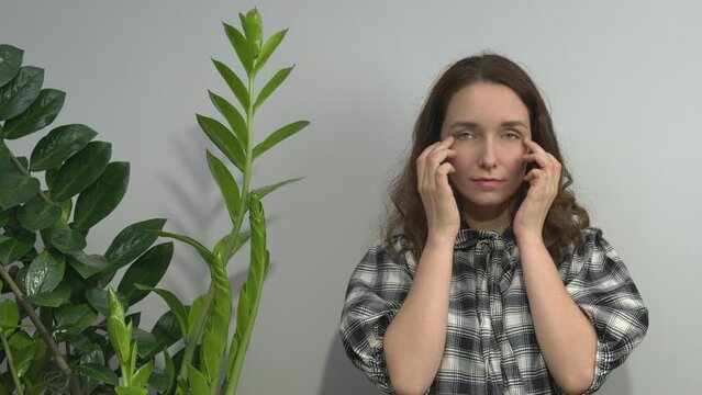 Person practicing EFT. Female tapping side of the eye (SE) meridian point. 