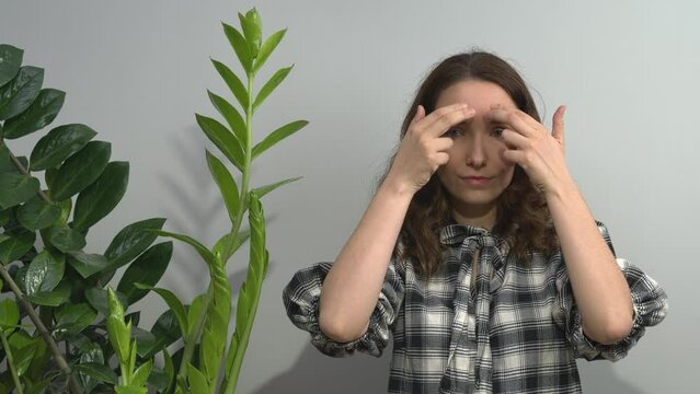 Person practicing EFT. Female tapping her eyebrow, inner eyebrow (EB) meridian point. 