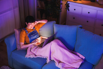 Obraz premium Mature Asian woman using laptop computer at home late at night