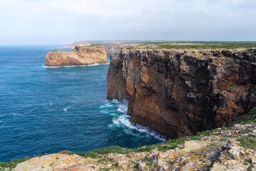 Die Wellen des Atlantik Meeres schlagen an die felsige Steilk&uuml;ste der Algarve in Portugal