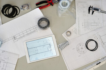 From above view flat lay shot of technical drawings, tools and digital tablet on table