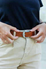 Women's leather belt for trousers. A brown belt on a woman's waist