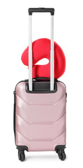 Red travel pillow on suitcase against white background