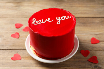 Bento cake with text Love You and paper hearts on wooden table. St. Valentine's day surprise
