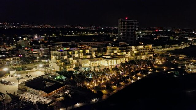 Aerial view evening pathos of Cyprus. Beautiful cityscape lights of a resort and tourist town on the shores of the Mediterranean Sea. High quality 4k footage