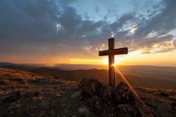 a cross on a hill with the sun shining through it