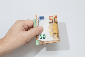 Hand holding many euro banknotes