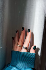 Female hand with green nail polish and stylish rings