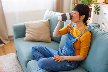 Woman drinking coffee while relaxing at home