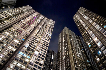 Fototapeta na wymiar Low angle view of modern skyscrapers at night, towering above