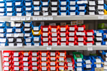 Blurred background with shelves with a large number of trays with fasteners, accessories and small consumables