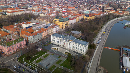 Fototapeta na wymiar Drone footage from downtown of Szeged, Hungary on a sunny winter day. Szeged, Drone, Aerial, Hungary, Urban Landscape, Szeged Cathedral, Tisza River, Bridge