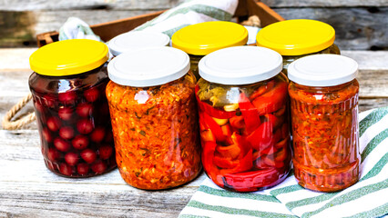 Jars with variety of canned vegetables and fruits, jars with zacusca. Preserved food concept in a...