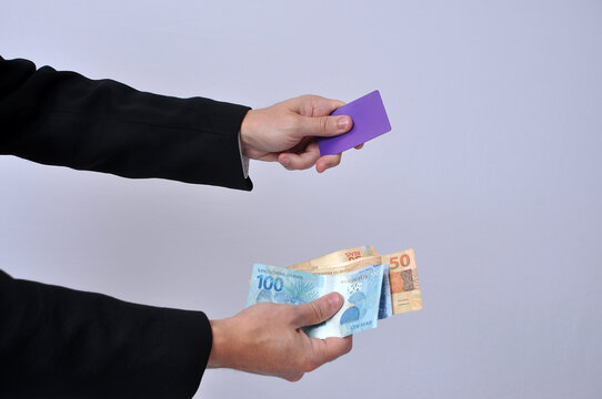 mão segurando dinheiro outra segurando cartão de credito 