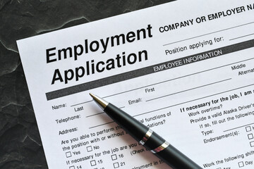 Obraz premium Filling out a job employment application. Looking for work. Trying to get hired, change careers.