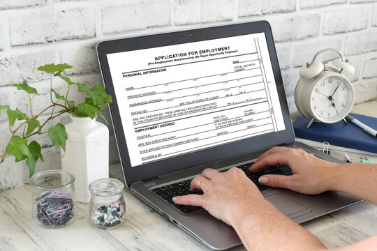 Filling out a job employment application online on laptop computer. Looking for work. Trying to get hired, change careers.