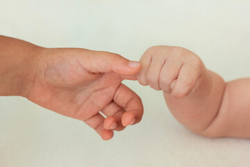 Newborn baby tightly grasps his sister's (brother's) finger. Unconditional love