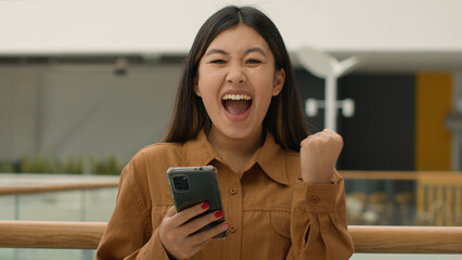 Shocked excited businesswoman client win online bet celebrate victory happy Asian korean japanese...