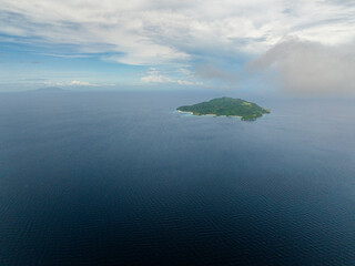 Aerial view of Cobrador Island surrounded by deep blue sea in Romblon, Philippines.