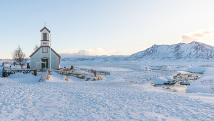 Beautiful old church near Keldur turf house farm, in the south of Iceland during winter. Catholic church in iceland with snowy landscape in the background with soft afternoon light. Travel destination