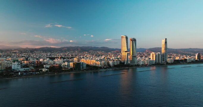 Sunset Over Limassol City, Republic of Cyprus at golden hour. Aerial Perspectives of Limassol's Modern Urban Landscape with High-Rise Glass Structures. 
