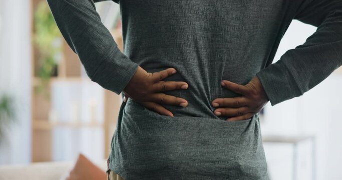 Back pain, hands and man in house with joint inflammation, crisis or anatomy risk closeup. Backache, problem or male person at home with kidney stones, discomfort or muscle, ache or posture disaster