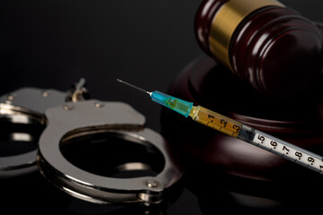 Syringe with gavel and handcuffs. Lethal injection, death penalty and capital punishment concept. - obrazy, fototapety, plakaty