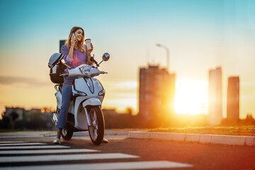  Girl on scooter talks on phone at sunset