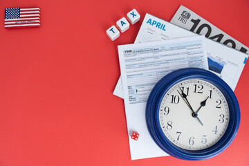 Clocks, dollars and tax forms on the table. Tax season concept.