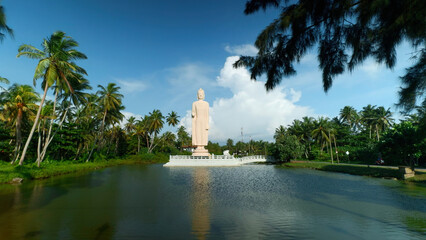 Tsunami Honganji Vihara, Hikkaduwa, Sri Lanka. Action. Beautiful white statue among green palm...