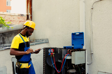 Competent mechanic doing air conditioner checkup, looking for leaks and other necessary repairs to...