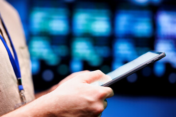 Close up shot of computer scientist using tablet to check server hub security features protecting...