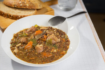 Dish of lentil stew with pig's ear, green pepper and carrot