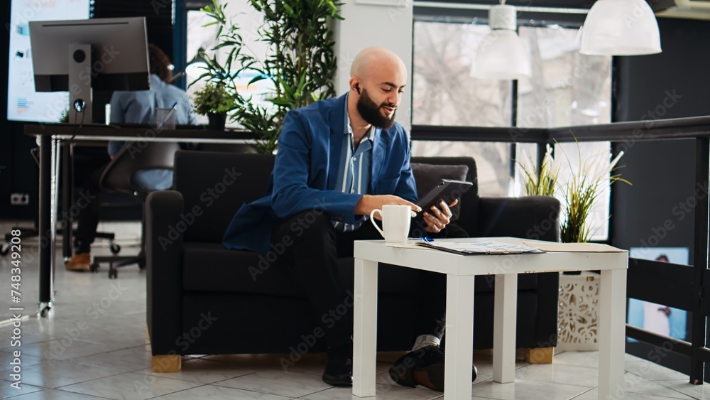 Poster analyst attends videoconference in open space office, middle eastern company employee using remote v