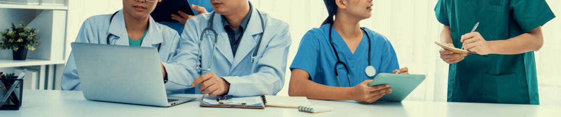 Professional various team of medical working and planning medical treatment at hospital table...