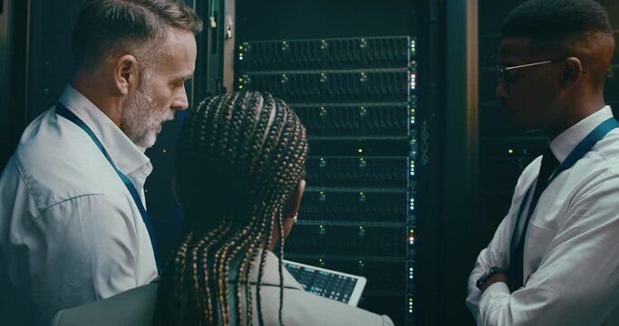 Team, tablet and server room for coding solution, programming and cloud computing on digital screen. Back of manager, technician or group of people in data center, system or hardware problem solving