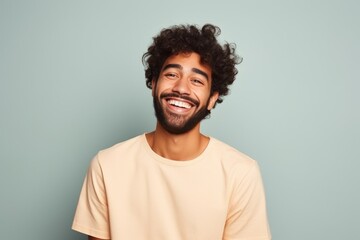 Fototapeta na wymiar Portrait of a happy young african american man laughing against blue background
