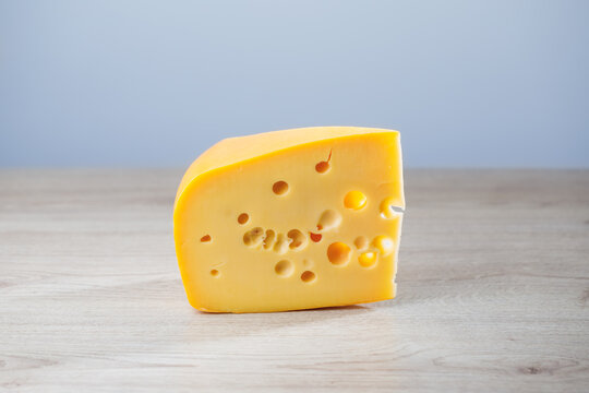 maasdam cheese on wooden background, close-up view