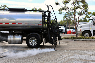 asphalt pavers putting down a layer of fresh oil