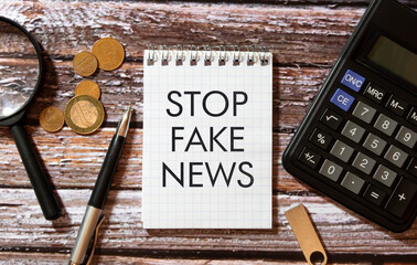 Woman holding megaphone and placard with text STOP FAKE NEWS on dark background