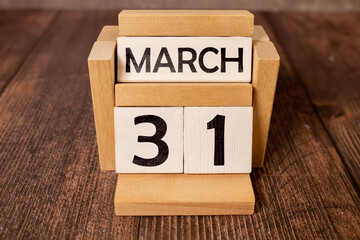 March 31st. Image of march 31 wooden color calendar on white brick wall background. empty space for...