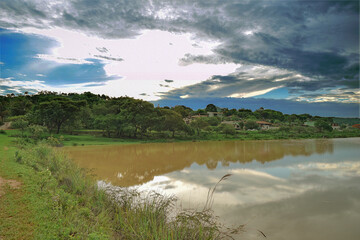 Beautiful morning on the lakeshore, with cloudy skies and reflections in the water, located in Esmeraldas, Minas Gerais.