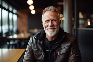 Portrait of a handsome senior man sitting in a cafe and smiling - obrazy, fototapety, plakaty