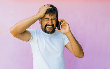 retrato de estudio de hombre llamando por teléfono celular y con expresiones de angustia