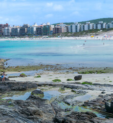 Part of Praia do Forte, with lots of rocks, people strolling. In the city of Cabo Frio, Rio de Janeiro.